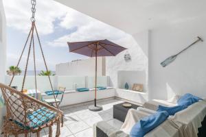 a living room with a chair and an umbrella at Vistamar in Puerto del Carmen