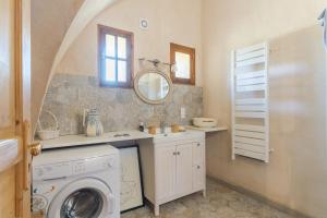 a bathroom with a washing machine and a sink at L'Amaryflor in Vaugines