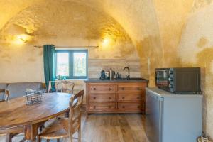 a kitchen with a wooden table and a microwave at L'Amaryflor in Vaugines
