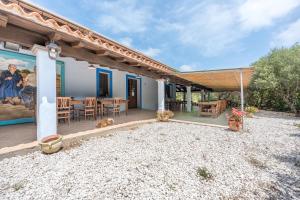 a house with a patio with a table and chairs at Su Birde Agriturismo in Orosei