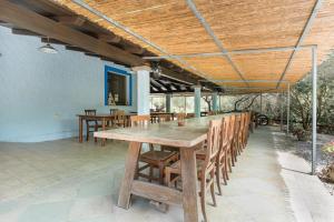 a wooden table and chairs on a patio at Su Birde Agriturismo in Orosei +51 photos