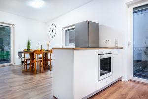 a kitchen with a refrigerator and a table with chairs at Cozy Ground Floor Apartment in Bremen