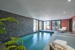a swimming pool in a room with a brick wall at Chalet avec Piscine La Plagne in La Plagne Tarentaise