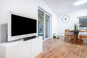 a living room with a flat screen tv on a white cabinet at Cozy Ground Floor Apartment in Bremen