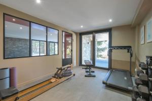 a gym with treadmills and a treadmill and windows at Chalet avec Piscine La Plagne in La Plagne Tarentaise