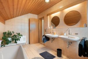 a bathroom with two sinks and a tub at Ferienwohnung Dorfidyll in Jesenwang +30 photos