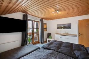 a bedroom with a large bed and a wooden ceiling at Ferienwohnung Dorfidyll in Jesenwang