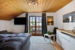 a bedroom with a bed and a wooden ceiling at Ferienwohnung Dorfidyll in Jesenwang