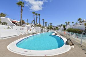 a swimming pool at a resort with palm trees at Puerto Chico 1 in Playa Blanca