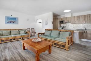 a living room with couches and a table and a kitchen at Puerto Chico 1 in Playa Blanca