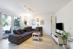 a living room with a couch and a flat screen tv at Villa Black Forest in Adelhausen