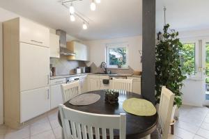 a kitchen with a table and chairs in a kitchen at Villa Black Forest in Adelhausen