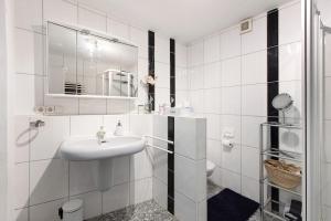 a person taking a picture of a bathroom with a sink at Villa Black Forest in Adelhausen +14 photos