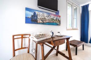 a room with a wooden table and a tv on the wall at Villa Massa depandance in Polignano a Mare