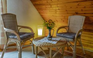 two chairs and a table with a vase of flowers at Kornbauernhof in Oberharmersbach
