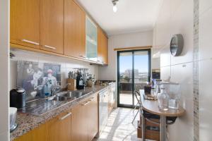 a kitchen with wooden cabinets and a counter top at Sunset House Algarve in Faro