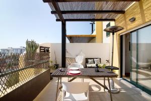 a patio with a table and chairs on a balcony at Sunset House Algarve in Faro