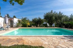 a swimming pool in the backyard of a villa with trees at Villa Massa depandance in Polignano a Mare +17 photos