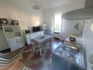 a kitchen with a stove and a table in a room at Garibaldi vista Giardino in Bonassola