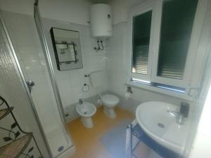 a white bathroom with a toilet and a sink at Garibaldi vista Giardino in Bonassola +7 photos