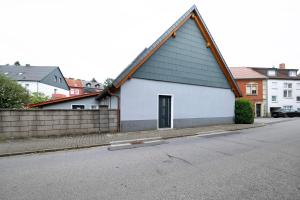 a white building with a black roof on a street at Fewo Weber in Sankt Ingbert