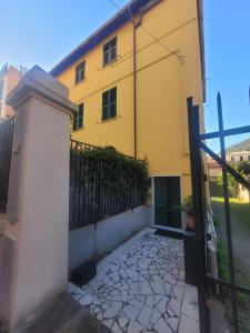 a yellow house with a gate and a fence at Garibaldi vista Giardino in Bonassola