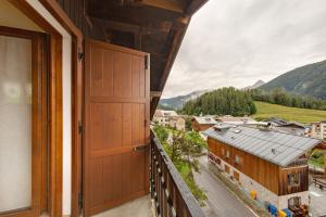 an open door to a balcony with a view of a town at La Casa dei Cervi a Vinigo in Vodo Cadore