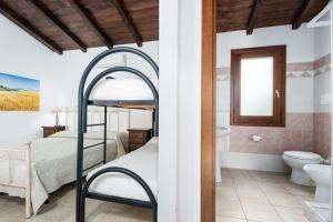 a bedroom with a bunk bed and a bathroom at Su Birde Agriturismo in Orosei