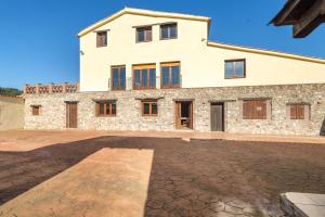 a large stone building with a lot of windows at Can Llevorer in Caldes de Montbui