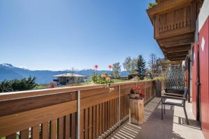 a balcony with a wooden railing and a chair at Alber Ferienwohnung Mürri in Verano