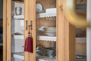 a cabinet filled with dishes and a red umbrella at Alber Ferienwohnung Mürri in Verano +30 photos