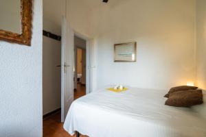a bedroom with a white bed with two pillows on it at Casa Luisella in Costa Rei