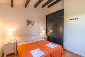 a bedroom with a bed with an orange blanket at Casa 6 U en Complejo Binisafua in Binisafua