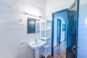 a white bathroom with a sink and a mirror at Casa 6 U en Complejo Binisafua in Binisafua +18 photos