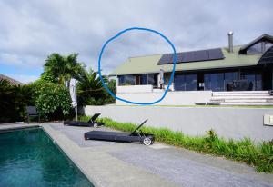 a blue hose is attached to a house next to a swimming pool at Riverview Retreat in Kerikeri +2 photos