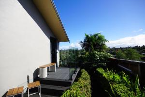 a balcony of a house with two chairs and a tree at Riverview Retreat in Kerikeri