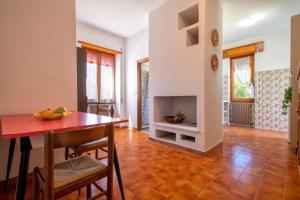 a dining room with a table and a fireplace at Spacious home in Costa Rossa in Trinità d'Agultu e Vignola