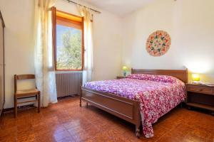 a bedroom with a bed and a window and a chair at Spacious home in Costa Rossa in Trinità d'Agultu e Vignola