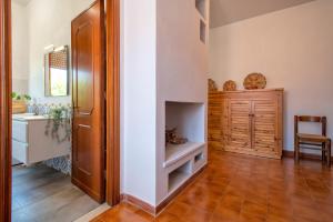 a hallway with a door and a table and a chair at Spacious home in Costa Rossa in Trinità d'Agultu e Vignola +24 photos