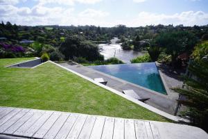 a backyard with a swimming pool and a river at Riverview Retreat in Kerikeri