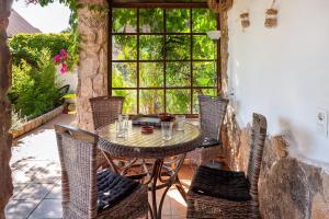 a table and chairs on a patio with a window at Casa Balcón - Sólo Familias in Los Caños de Meca