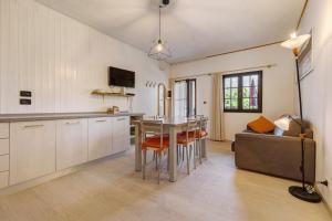 a kitchen and living room with a table and a couch at Casa Berthold in Ledro