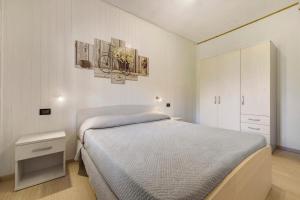 a white bedroom with a bed and a white cabinet at Casa Berthold in Ledro