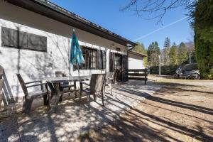 a patio with a table and chairs and an umbrella at Casa Berthold in Ledro