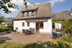 a white house with chairs and a patio at Haus Marianne in Arnsberg