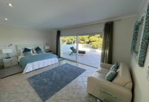 a bedroom with a bed and a couch and a window at Gloriann in Moraira +18 photos