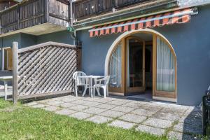 a patio with a table and chairs in front of a house at Sabina Dolomites Euringer in Alpe di Siusi