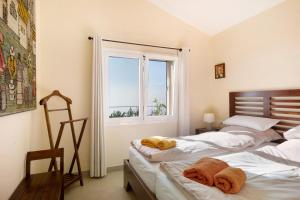 two beds in a room with a window at Casa Inti in Tijarafe
