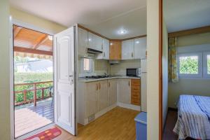a kitchen with a door open to a balcony at Bungalow B1 in Pontevedra