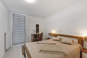 a bedroom with a bed and a desk and a chair at eva Ferienwohnung in Engen